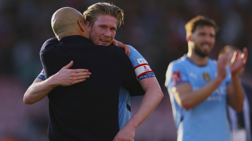 Manchester City's Kevin De Bruyne, center, celebrates with Manchester City's head coach Pep Guardiola, left, at the end of the English FA Cup quarterfinal soccer match between Bournemouth and Manchester City at the Vitality stadium in Bournemouth, England, Sunday, March 30, 2025. (AP Photo)