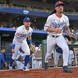 Kansas City Royals third baseman Jonathan India (6) and second baseman Michael Massey (19) run onto the field before a game against the Chicago White Sox at Kauffman Stadium.