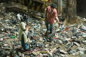 Footwears lie on the ground outside the Chinnaswamy Stadium following a stampede