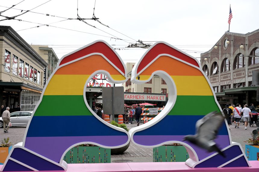 A heart shaped sign with the colours of the pride flag is seen near the Pike Place Market in Seattle, on June 25, 2025.
