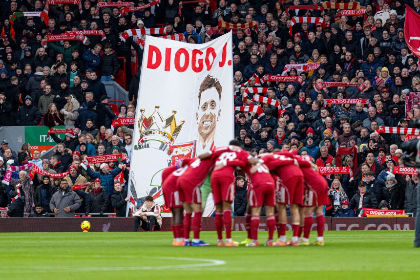 Liverpool's players huddle in front of a banner bearing a tribute to Diogo Jota during the Premier League match between Liverpool and Wolverhampton Wanderers at Anfield in Liverpool, England, on December 27, 2025.