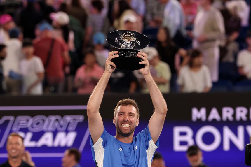 Australia's Jordan Smith celebrates with the trophy after defeating Taiwan's Joanna Garland in the One Point Slam exhibition event ahead of the 2026 Australian Open.