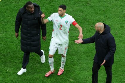 Senegal's head coach Pape Thiaw, left, Morocco's head coach Walid Regragui, right, and Morocco's Achraf Hakimi argue after a controversial penalty was awarded in the AFCON final. (AP Photo)