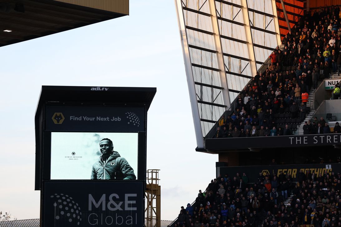 Fans take part in a moment's silence in remembrance of former academy player Ethan McLeod prior to the Premier League match between Wolverhampton Wanderers and Brentford at Molineux on December 20, 2025 in Wolverhampton, England.