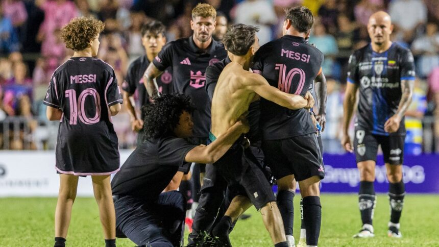 A fan who got onto the field grabs Inter Miami's Lionel Messi at the end of an international friendly soccer match against Ecuador's Independiente del Valle in Bayamon, Puerto Rico, Thursday, Feb. 26, 2026. (AP Photo)