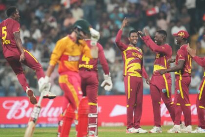 West Indies' Akeal Hosein, centre, celebrates with teammates the wicket of Zimbabwe's Brian Bennett during the T20 World Cup cricket match between Zimbabwe and West Indies in Mumbai, India, Monday, Feb. 23, 2026. (AP Photo)