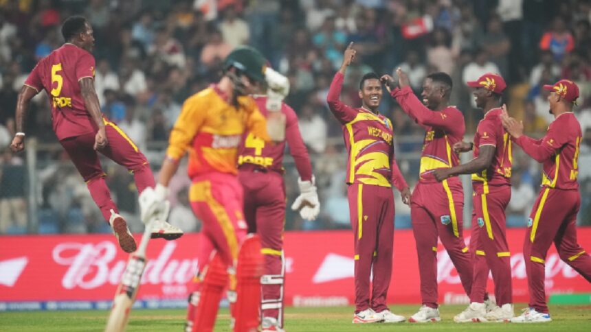 West Indies' Akeal Hosein, centre, celebrates with teammates the wicket of Zimbabwe's Brian Bennett during the T20 World Cup cricket match between Zimbabwe and West Indies in Mumbai, India, Monday, Feb. 23, 2026. (AP Photo)