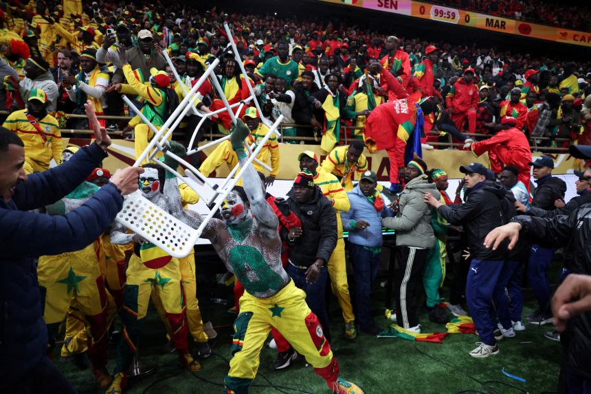 Senegal fan clashes with security as fans invade the pitch after Morocco was awarded a penalty following a VAR review in Rabat, Morocco, on January 18.
