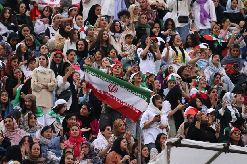 Iran supporters cheer for their team during a match in Tehran in June.