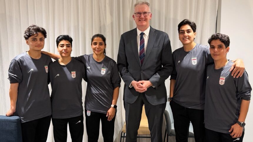 Australia's Minister for Home Affairs Tony Burke (center) poses with five Iranian women soccer players who have been granted asylum in Australia. (Australia Ministry of Home Affairs via AP)