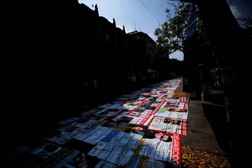 Large banners displaying search flyers of missing people are laid out on the ground in front of the Jalisco Government Palace on March 22, 2026, to draw attention to the problem ahead of the 2026 FIFA World Cup.