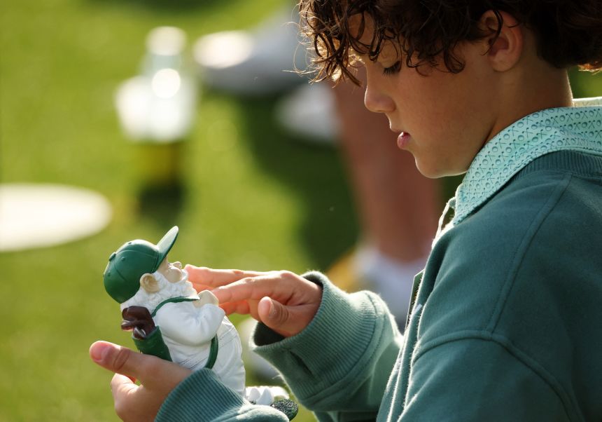 A child is seen with a Masters garden gnome souvenir during a practice round in the Masters golf tournament in Augusta, Georgia, on April 6.
