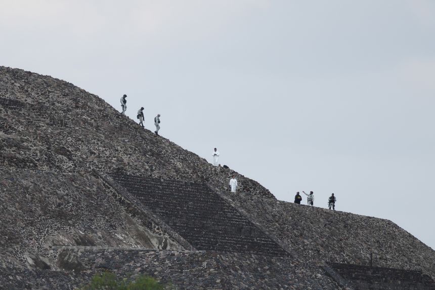 Police and forensic workers stand on a pyramid after authorities said a gunman opened fire in Teotihuacan, Mexico, on Monday.