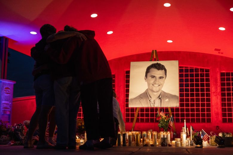 People pay their respects during a candlelight vigil for youth activist and influencer Charlie Kirk at a makeshift memorial in Orem, Utah on September 11, 2025.