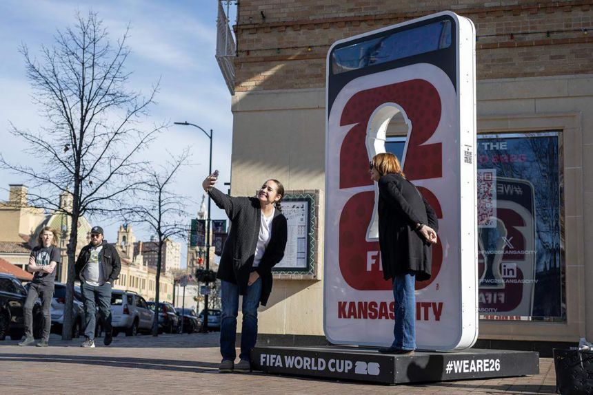 People take photos next to a FIFA World Cup 26 sign in Kansas City, Missouri, in December.