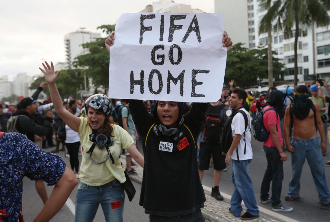 A protester holds a "FIFA Go Home" sign during an anti-World Cup demonstration in June 2014 in the Copacabana section of Rio de Janeiro, Brazil. FIFA is no stranger to controversy and host countries often face criticism.