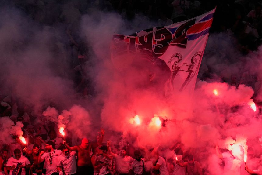 PSG fans light flares in the stands in Budapest, Hungary, on Saturday.