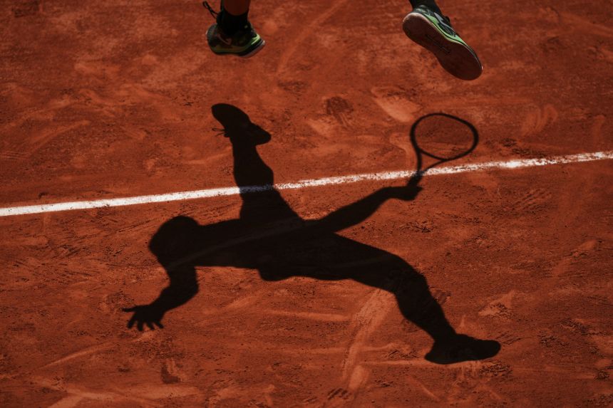 Camilo Ugo Carabelli casts a shadow as he serves to Andrey Rublev during their second round match on Wednesday.