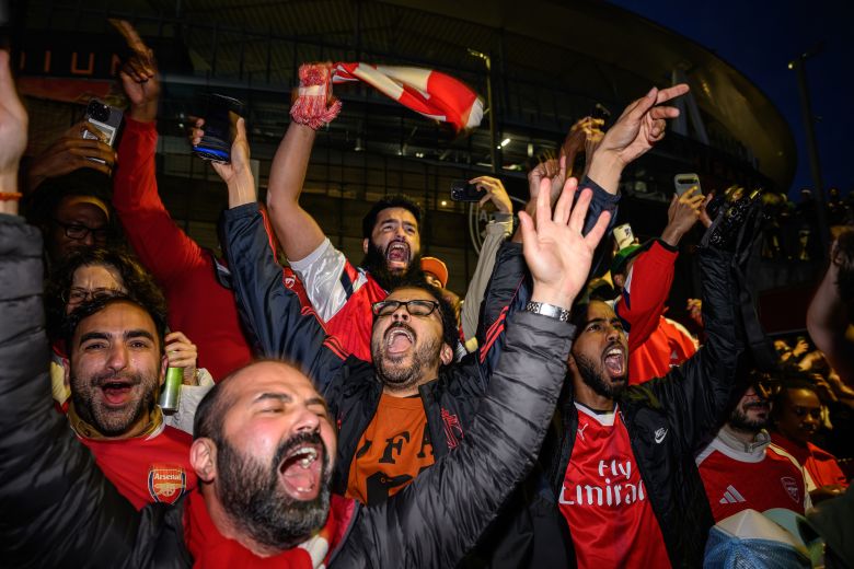 Fans celebrate outside the Emirates Stadium as Arsenal wins the Premier League title.