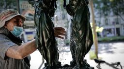 A man fills a glass of water at a public fountain in the Montparnasse district of Paris on May 25, 2026, as French weather service Météo-France placed the capital under yellow alert amid an exceptionally early heatwave, with temperatures forecast to reach 35C across the region. (Photo by STEPHANE DE SAKUTIN / AFP via Getty Images)