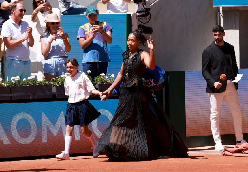 Osaka enters the court wearing her <a href="https://www.instagram.com/kevingermanier/?hl=en" target="_blank">Kevin Germanier</a>-designed dress.