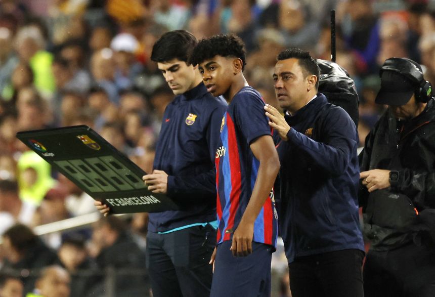 Yamal receives instructions from then Barça manager Xavi before his debut in April 2023.
