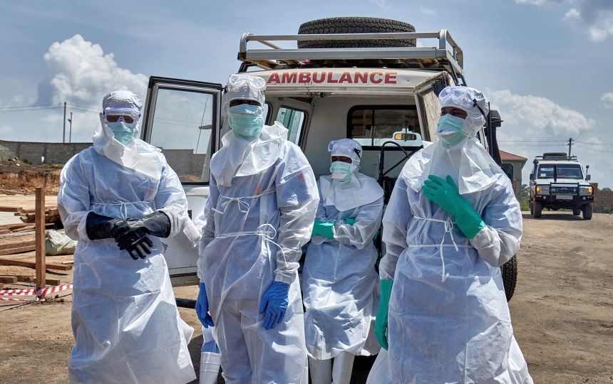 Red Cross workers wearing personal protective equipment (PPE) gather after handling the coffin of a man who died of Ebola virus in Bunia, Ituri province, DR Congo on June 10.