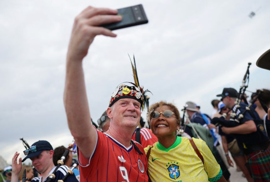 Scotland and Brazil fans pose for a selfie during a World Cup march.