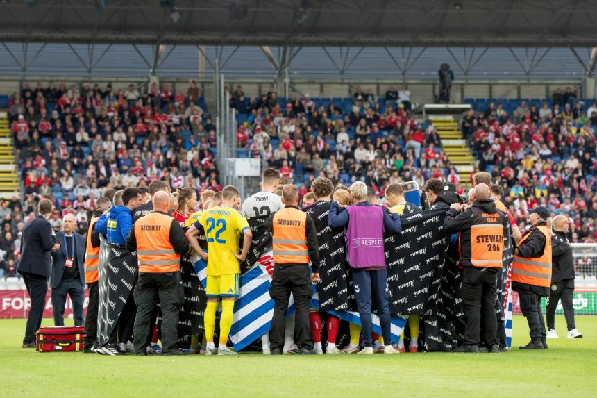 Players from Denmark and Ukraine form a circle around Christian Eriksen after he collapsed.