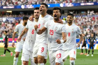 Iran's Ramin Rezaeian celebrates with his teammates after scoring a goal during the World Cup Group G soccer match between Iran and New Zealand Monday.