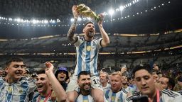 LUSAIL CITY, QATAR - DECEMBER 18: Lionel Messi of Argentina celebrates with the FIFA World Cup Qatar 2022 Winner's Trophy on Sergio 'Kun' Aguero's shoulders after the team's victory during the FIFA World Cup Qatar 2022 Final match between Argentina and France at Lusail Stadium on December 18, 2022 in Lusail City, Qatar.  (Photo by David Ramos - FIFA/FIFA via Getty Images)