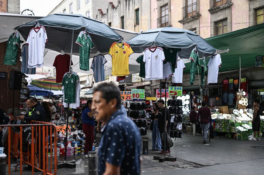 Unofficial sports jerseys from various national teams participating in the World Cup are displayed for sale at an informal street stall in the historic center of Mexico City on May 28.