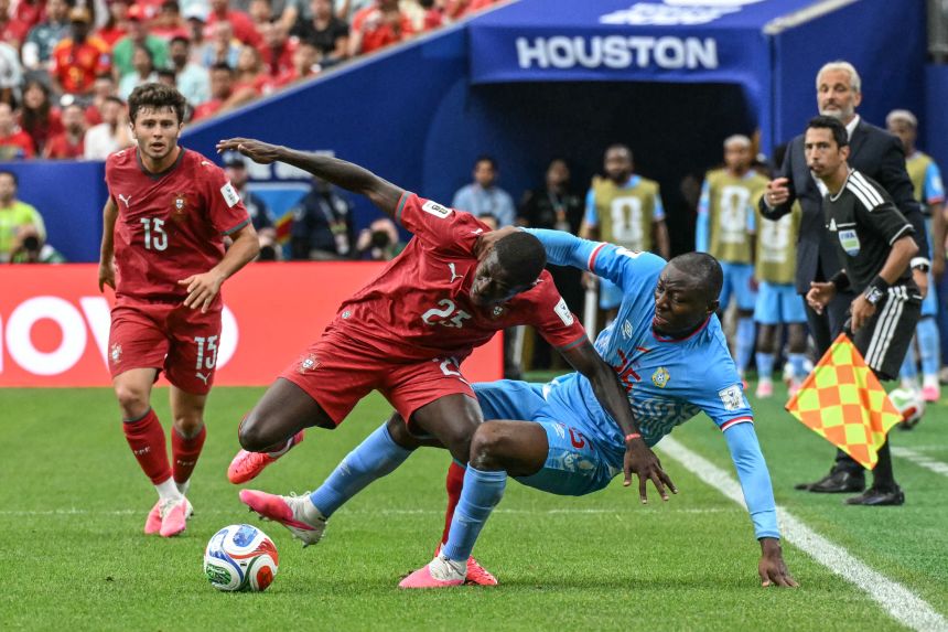 Portugal's Nuno Mendes, center, is challenged by DR Congo's Edo Kayembe.