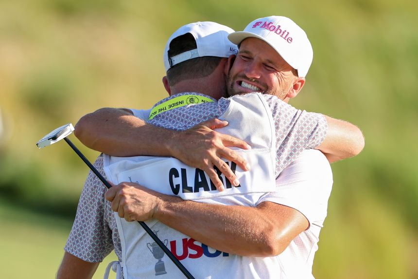 Clark embraces his caddie, David Pelekoudas, after winning his second career US Open.