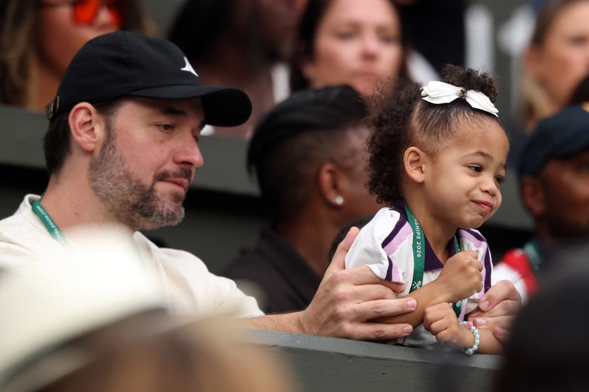 Serena Williams' husband, Alexis Ohanian, holds their daughter Adira as they watch the match on Tuesday.