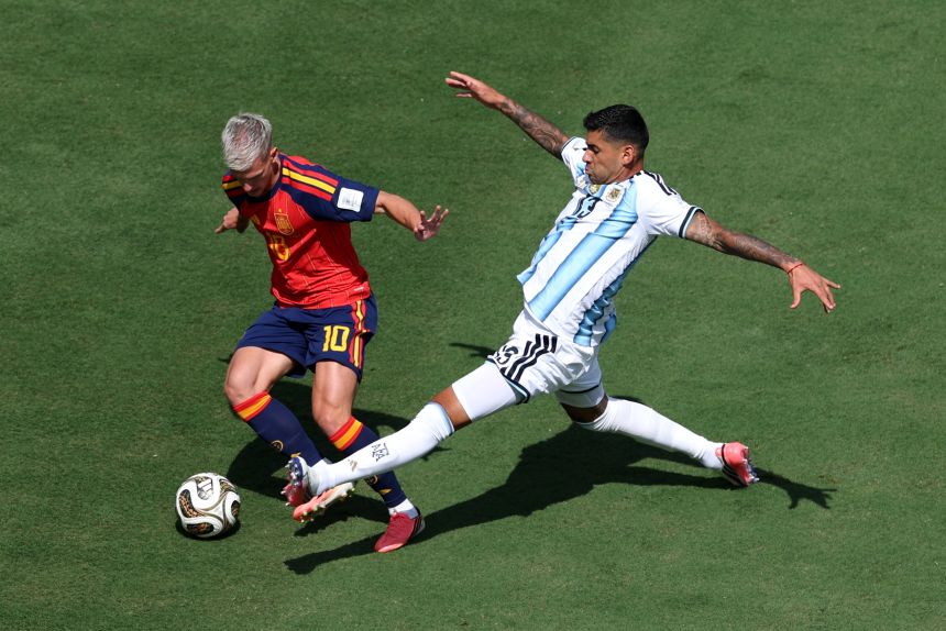 Dani Olmo of Spain (left) controls the ball against Cristian Romero of Argentina during the FIFA World Cup final on July 19.